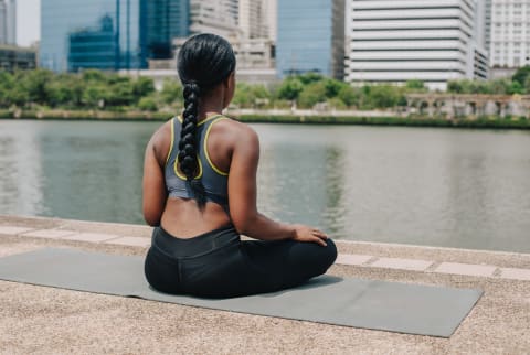 Woman Meditating Outdoors on a Yoga Matt Woman Meditating Outdoors on a Yoga Matt