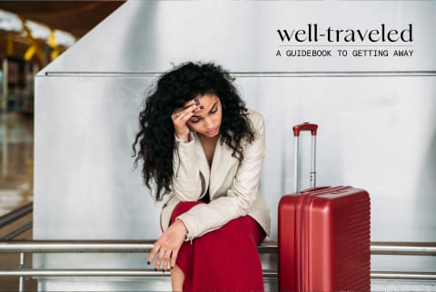 Woman with red carry on suitcase looking stressed at airport Woman with red carry on suitcase looking stressed at airport