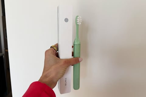 photo of SURI toothbrush and case in writer's hand